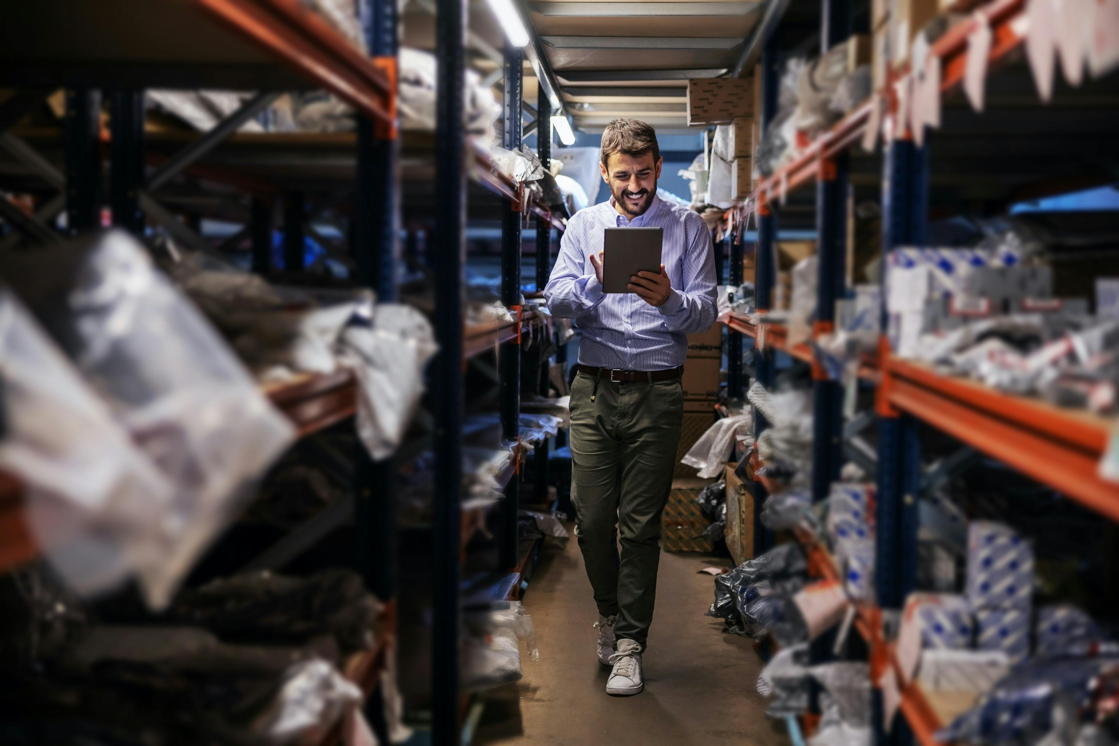 Man inspecting warehouse with tablet app